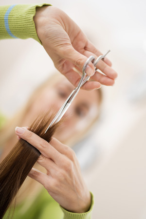 At the hairdresser's.Young female hairdresser cutting hair of a female customer.の写真素材