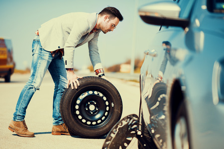 Changing tire on broken car on roadの写真素材
