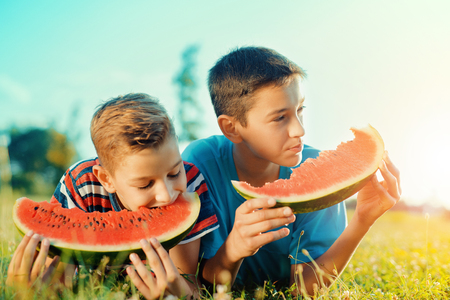 Happy children eating watermelon,healthy eating conceptの写真素材
