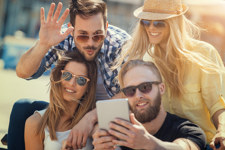 Group of cheerful young people taking selfie in the city.の写真素材