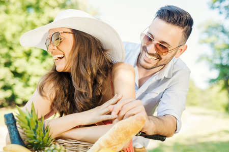 Happy couple going on a bike ride and picnic in nature.の写真素材