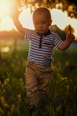 Learning to walk.Image of one year old baby boy having his first steps with the help of his mother.の写真素材