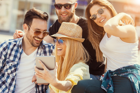 Group of friends taking a selfie with smartphone.の写真素材