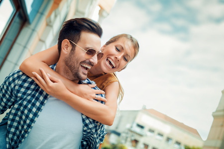 Man giving piggyback ride to woman in the city.の写真素材