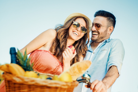 Happy couple going on a bike ride and picnic in nature.の写真素材