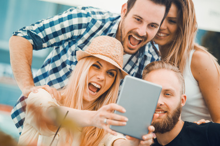 Group of friends taking a selfie with smartphone.