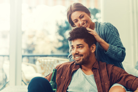 Close up of a young couple in love at home.They are sitting close to each other and enjoying together.の写真素材