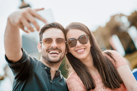 Young couple taking a selfie and having fun outdoors.の写真素材