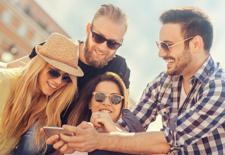 Group of friends taking a selfie with smartphone.