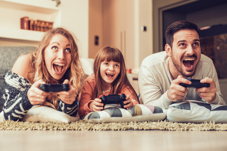 Playful family playing video games together in a living room.の写真素材