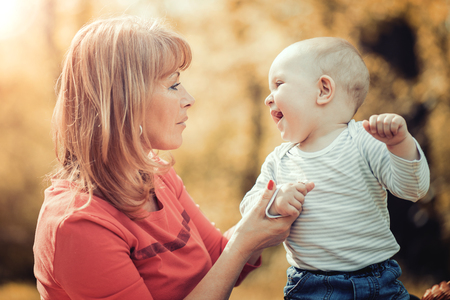 Happy mother with her little son in summer park.の写真素材