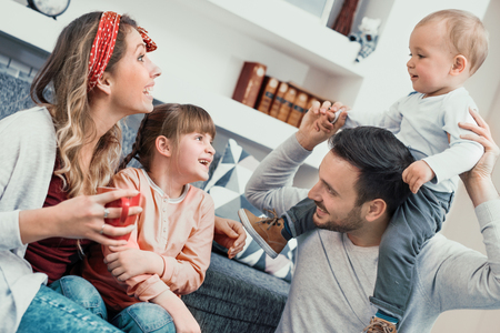 Happy family mother,father and children at home.の写真素材