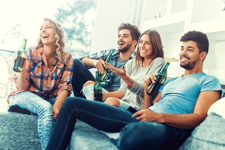 Cheerful group of friends having fun at home,watching game.の写真素材