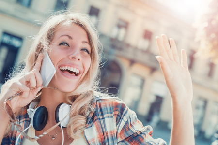 Young woman listening to music on a smart phone in the city.の写真素材