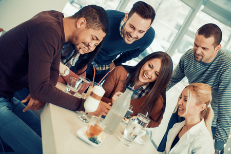 Friends smiling and sitting in a cafe, drinking coffee and enjoying together.の写真素材