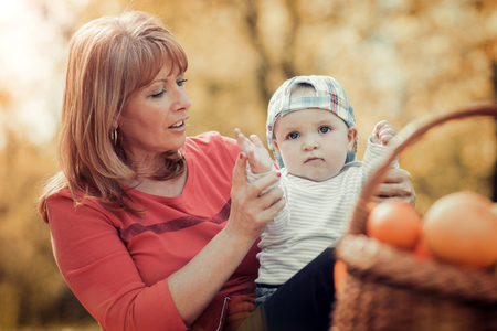Family in the autumn park.Mom playing with son child in the autumn nature. の写真素材
