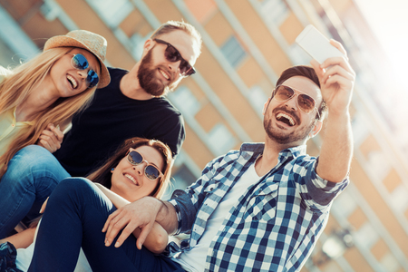 Best friends taking selfie outdoors.Happy young people having fun together.の写真素材