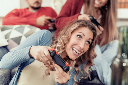 Group of friends having fun and  play video games together.