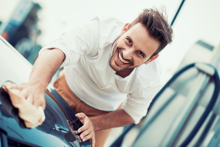 Man worker polishing car on a car wash outdoors.の写真素材
