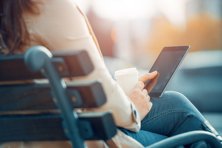 Woman use break at work to drink coffee and use digital tablet.の写真素材
