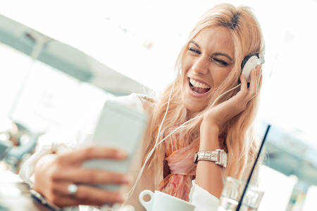Young woman listening to music on a smart phone.She is listening music on smartphone in the city.の写真素材