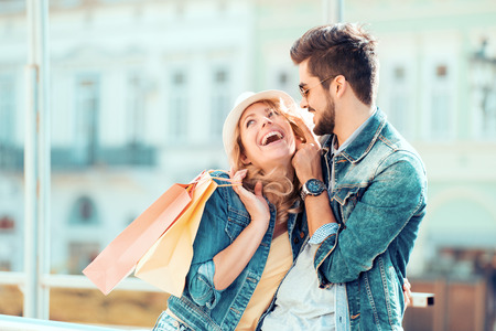 Young happy couple with shopping bags in the city.の写真素材