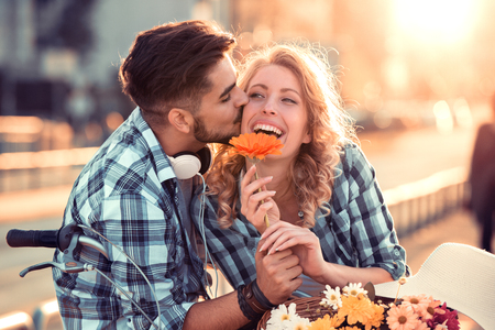 Happy young couple hugging and laughing outdoors.の写真素材