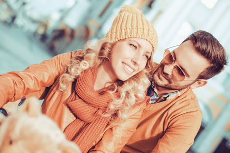Couple in love in autumn.Happy young couple going for a bike ride on a autumn day in the city.の写真素材
