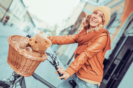 Beautiful smiling girl is riding the bicycle in the city.の写真素材