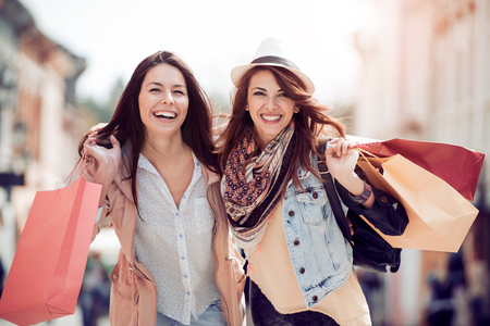 Happy women with shopping bags in the city.の写真素材