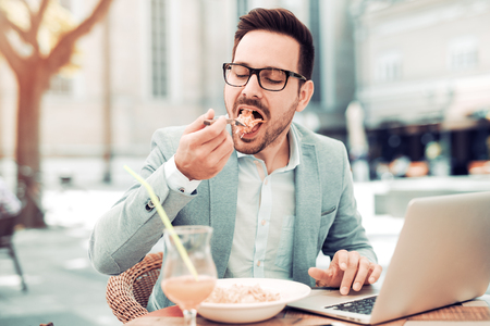 Businessman having a salad for lunch,healthy eating.He is working while taking a break.の写真素材
