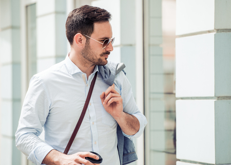 Happy smiling businessman drinking coffee to go outside.の写真素材