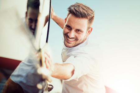 Man taking care and cleaning his car outdoors.の写真素材