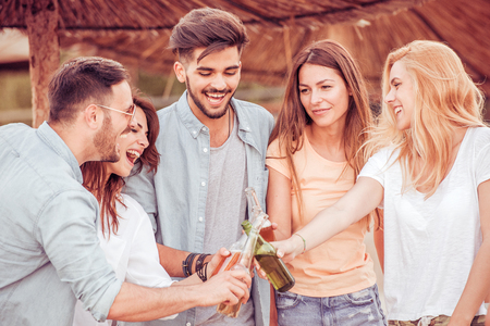 Friends drinking beers and listening to music.Having fun at beach party.の写真素材