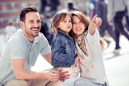 Parents and girl look happy and smile.Happiness and harmony in family life.Family fun outside.の写真素材