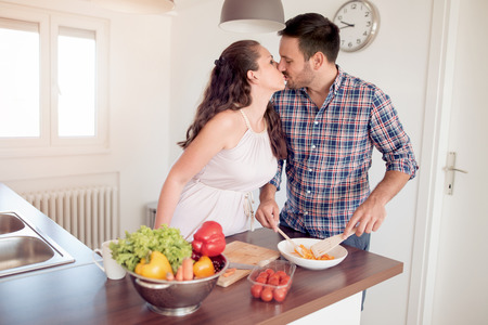 Romantic young couple cooking together in the kitchen.Young couple cutting vegetables in the kitchen.の写真素材