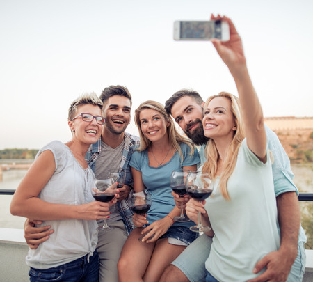 Friends having party outdoors,they are taking selfie.の写真素材
