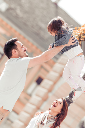 Happy family with one child having fun together in summer city park.の写真素材