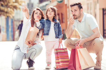 Happy family relaxing in the city on beautiful summer day and eating popcorn.の写真素材