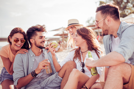 Group of cheerful young people relaxing on the beach.の写真素材