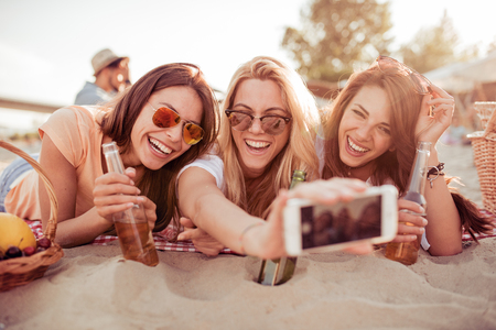 Three beautiful young woman having fun on the beach on a summer day.の写真素材