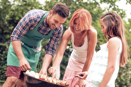 Young family having barbecue party, outdoors.の写真素材