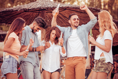 Group of friends enjoying summer vacation on a beach.の写真素材