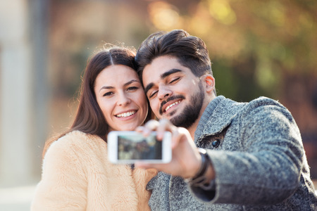 Romantic couple relaxing in the park,taking selfie.の写真素材