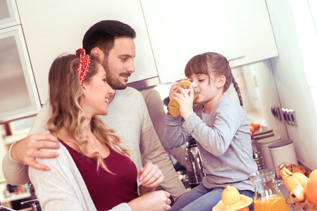 Young mother, father and child prepare fruits juice in kitchenの写真素材
