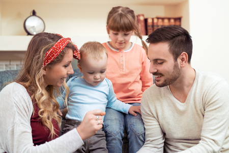 Happy family with kids on the couch,having fun together.の写真素材