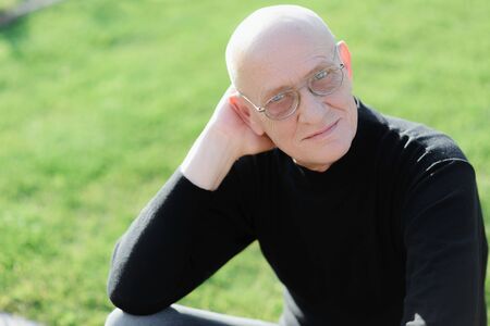 A happy old man with pensive playful expression