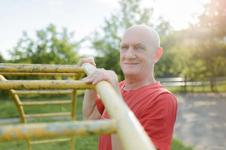 Portrait of middle aged sport man doing exercise in the park.