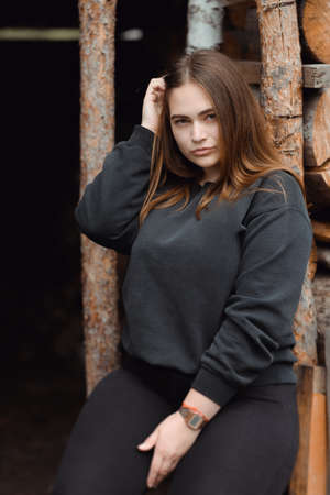 Shot of an attractive young woman sitting in front of wooden backgroundの写真素材