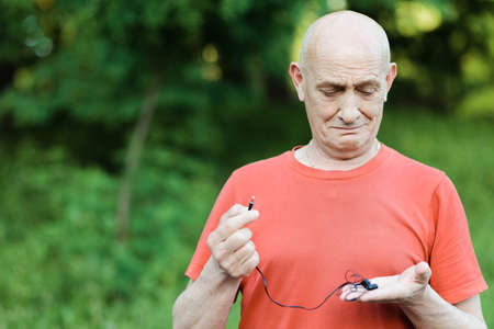 Close up portrait of senior man crying and looking at camera with red eyes.の写真素材